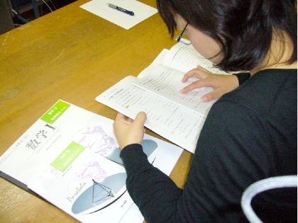 図2.4.7 好みの教科書を選択している様子:児童生徒が版サイズの異なる二冊の教科書を比較して好みの教科書を選択している様子を写した写真